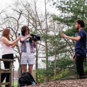 Marion Callahan and Media and Communication Students are outdoors filming.